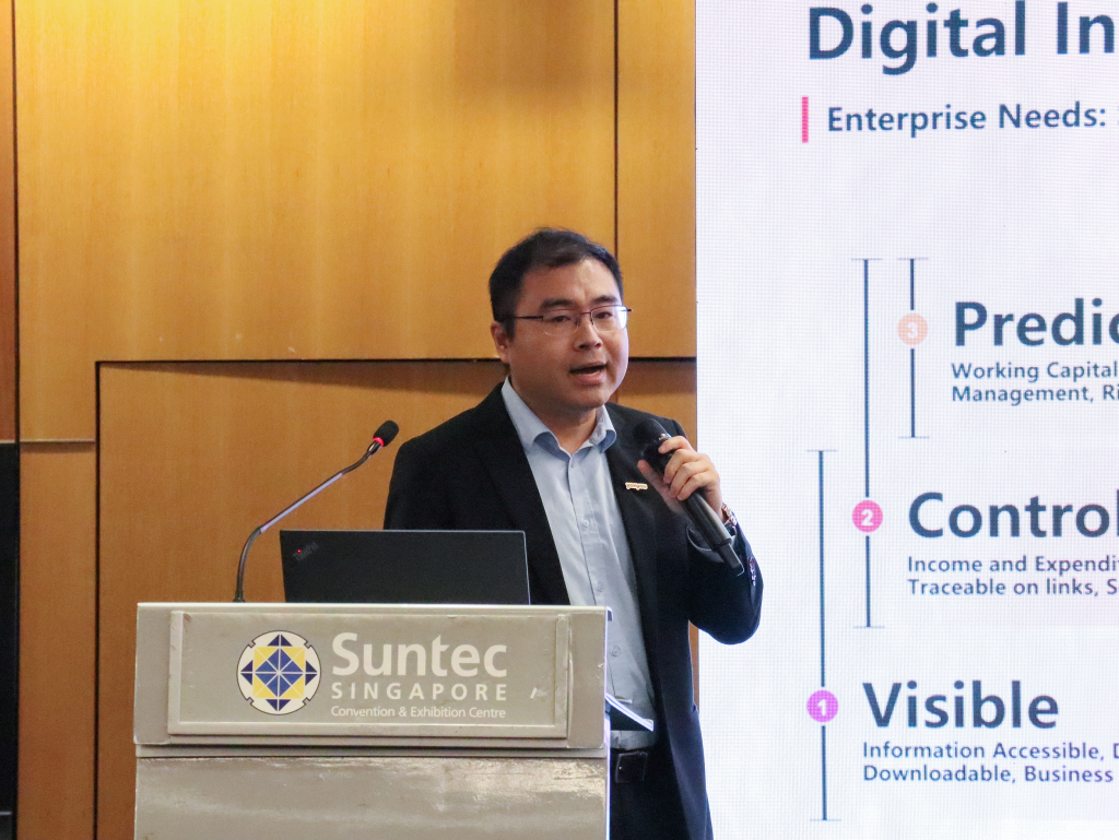 Ralph Yuan, Customer Growth & Product Development Director at Yonyou Network Technology, speaking beside the podium with a microphone. He highlights the seamless integration of three major Yonyou products with OCBC's banking platform to enhance business convenience and success.